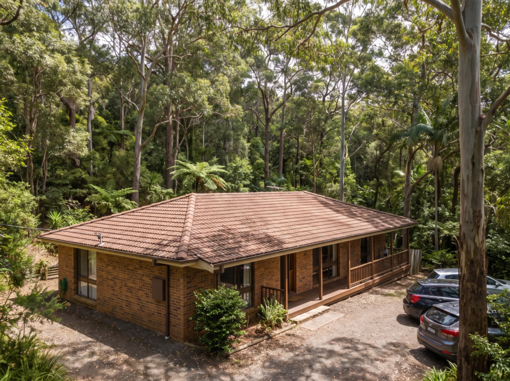 Family home under dense eucalypt canopy in Frenchs Forest with clean gutters and terracotta roof