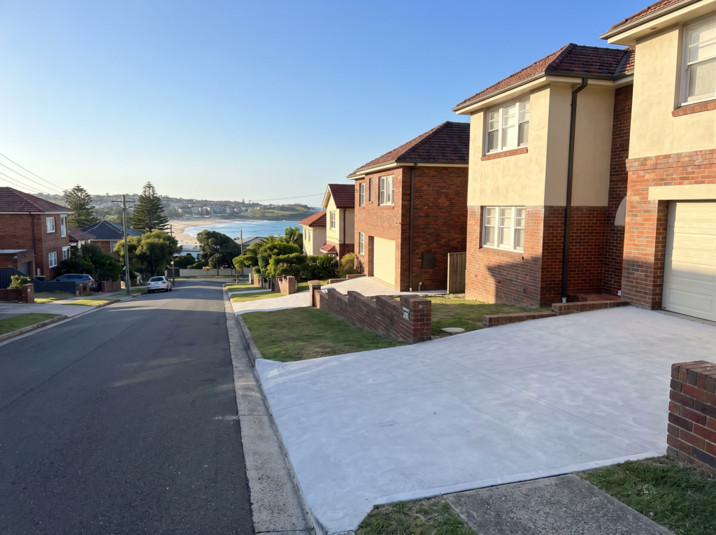 Interwar brick homes with wide clean driveways in Maroubra, beach in the distance