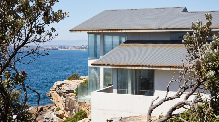 Contemporary Northern Beaches coastal home above the ocean showing salt haze on rendered walls, spotted glazing and tea staining on the Colorbond roof
