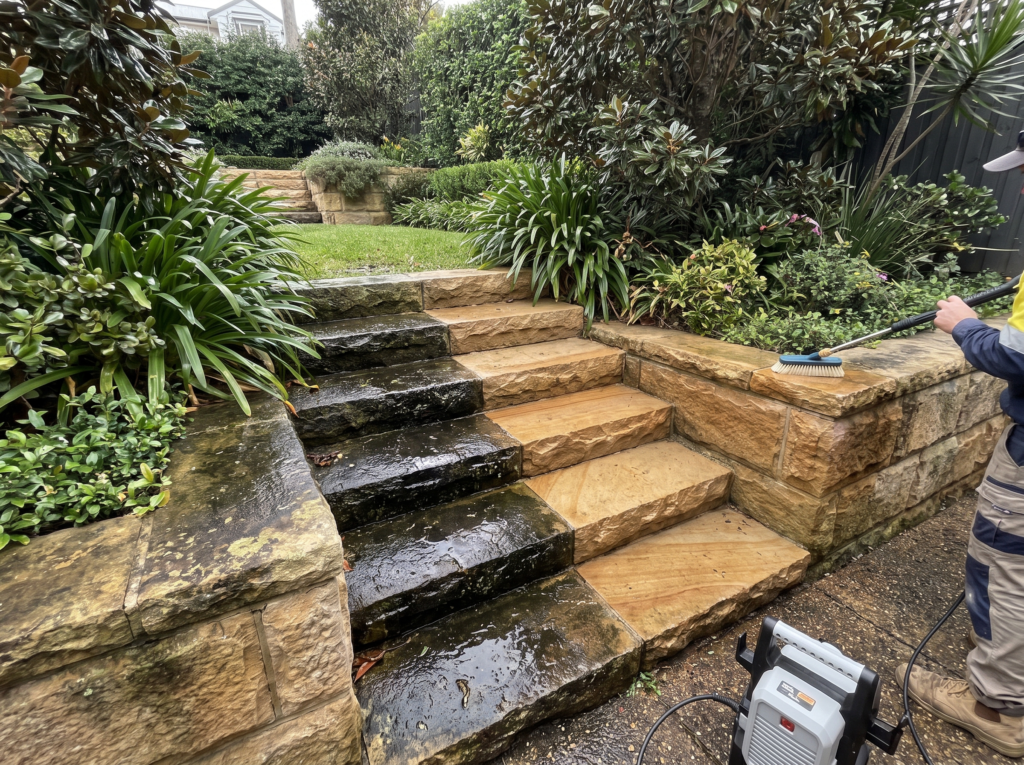 Golden sandstone steps and retaining wall being restored from black staining to warm gold