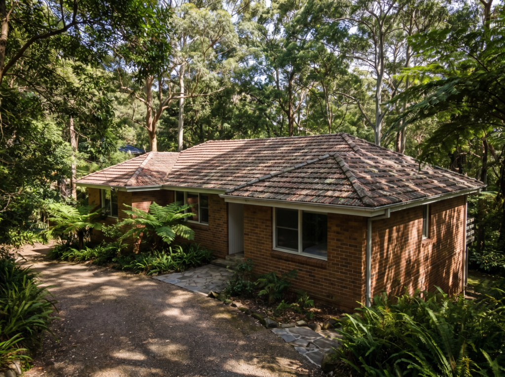 Turramurra home under extremely dense canopy with clean terracotta roof and clear gutters